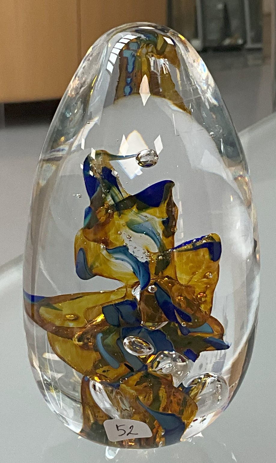 The Glass Paperweight displayed on a writing desk or in a glass cabinet, reflecting the style of 19th-century French decorative arts.